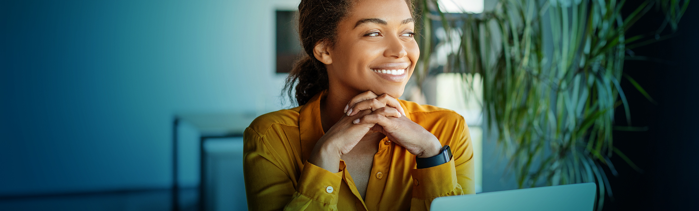 An adult smiling and looking away from the camera.